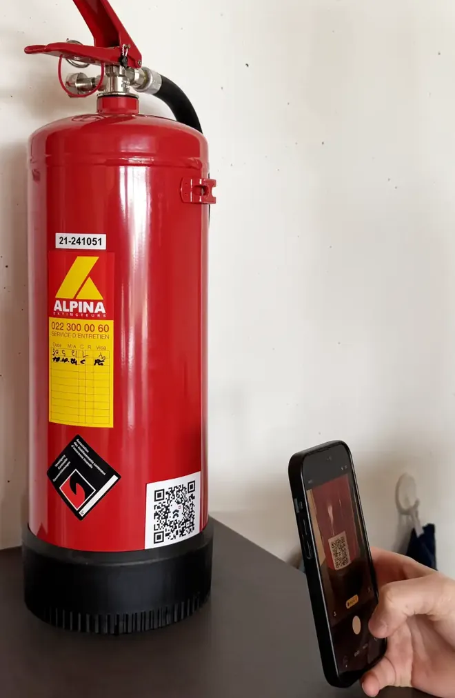 Extincteur muni d'une étiquette QR, lue avec un téléphone